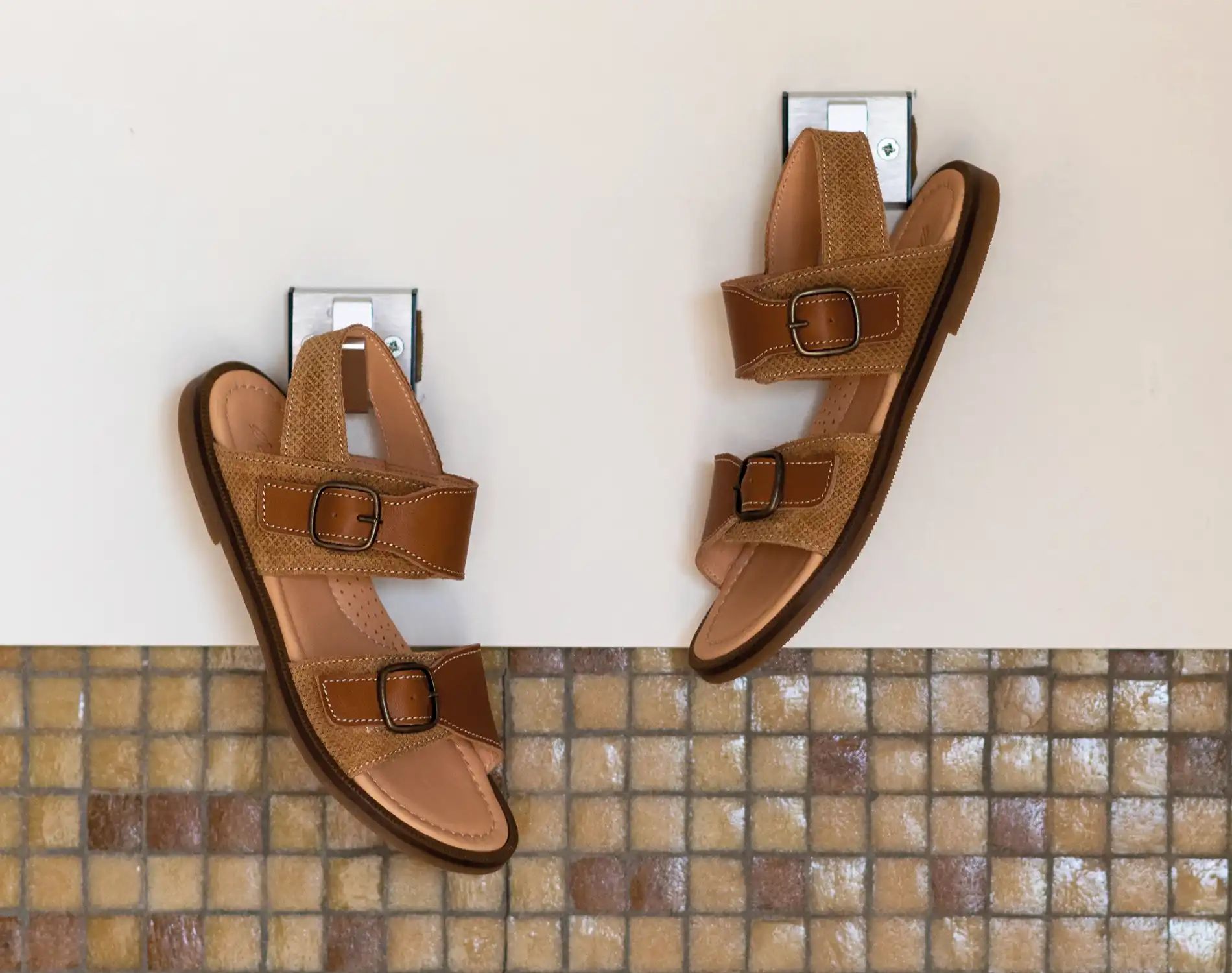Bruine sandalen met brede banden hangend aan kapstok