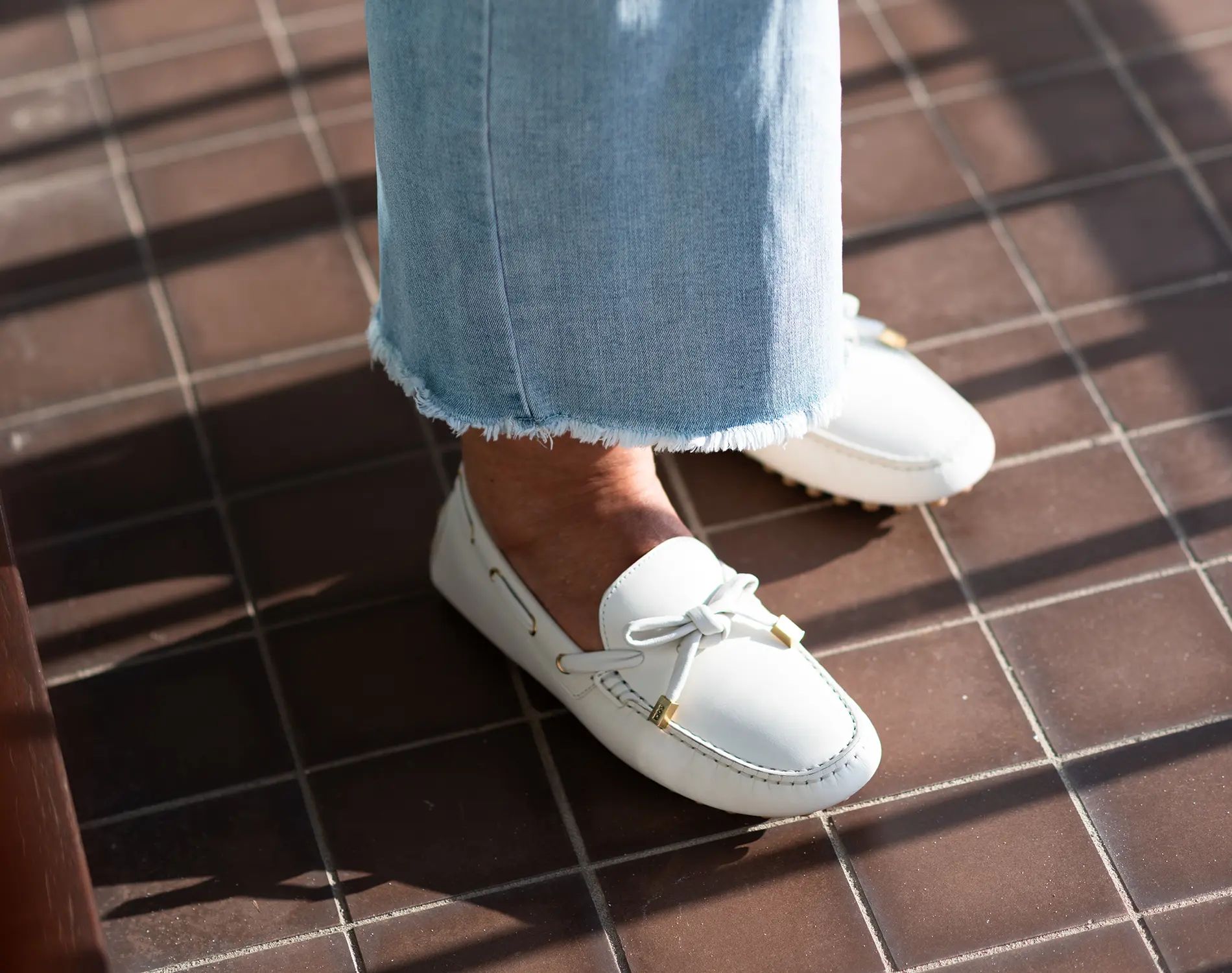 Witte loafers met metalen detail op tegelvloer